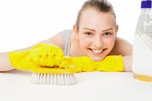 Professional cleaner sanitizing shared office surfaces in Nottinghill